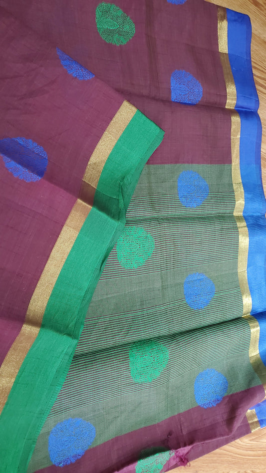 Saree with green and purple pattern on a wooden surface