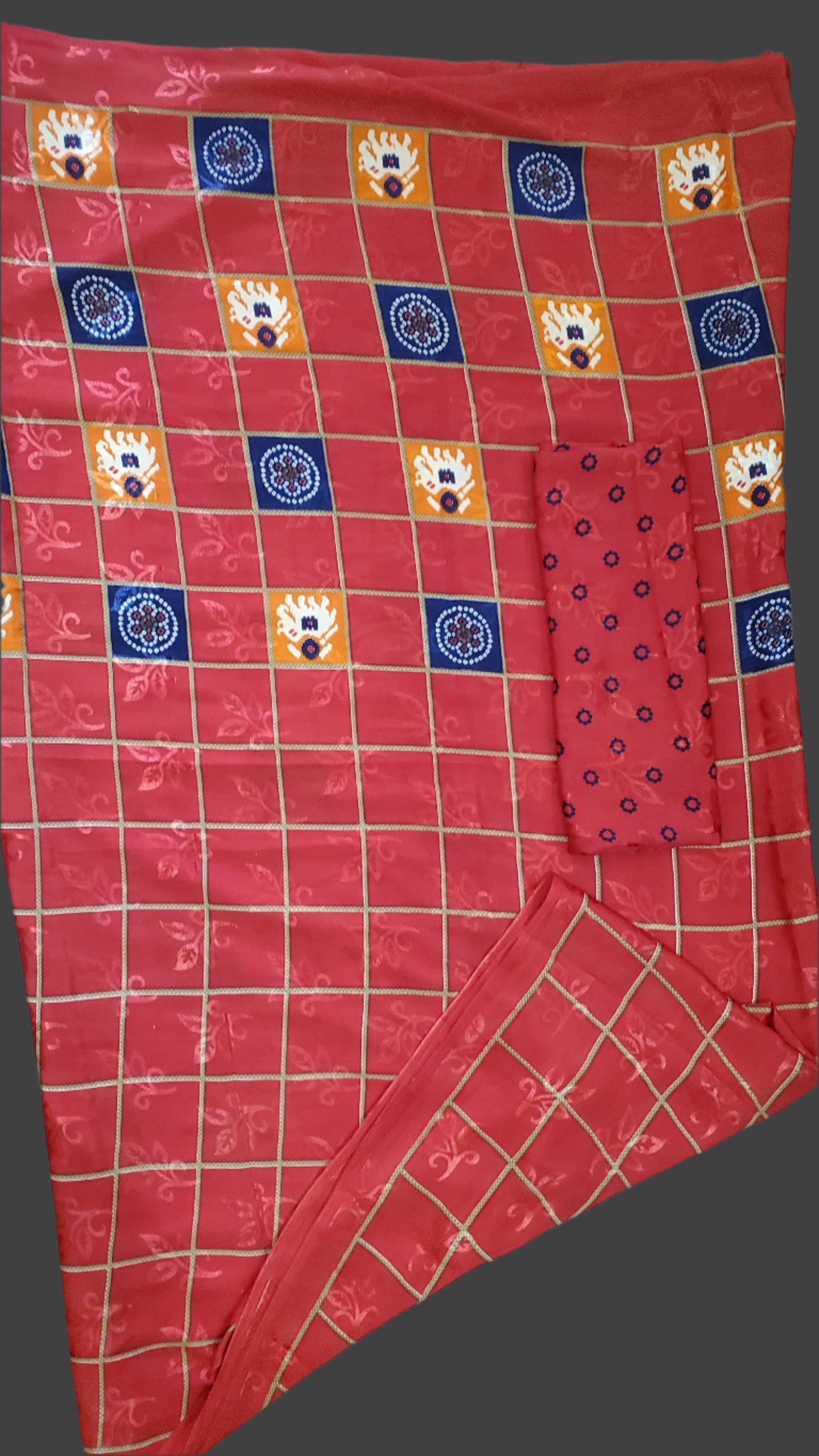 Red checkered fabric with patterned squares on a wooden surface