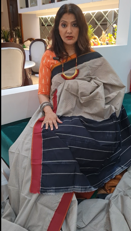Woman wearing a traditional saree with a striped pattern in an indoor setting